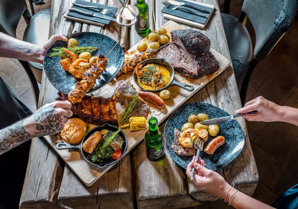 Fleisch, Gemüse und Fisch und andere frische Speisen auf dem Restauranttisch im Salzburger Land
