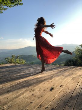 Christine May Yogalehrerin tanzt im roten Kleid